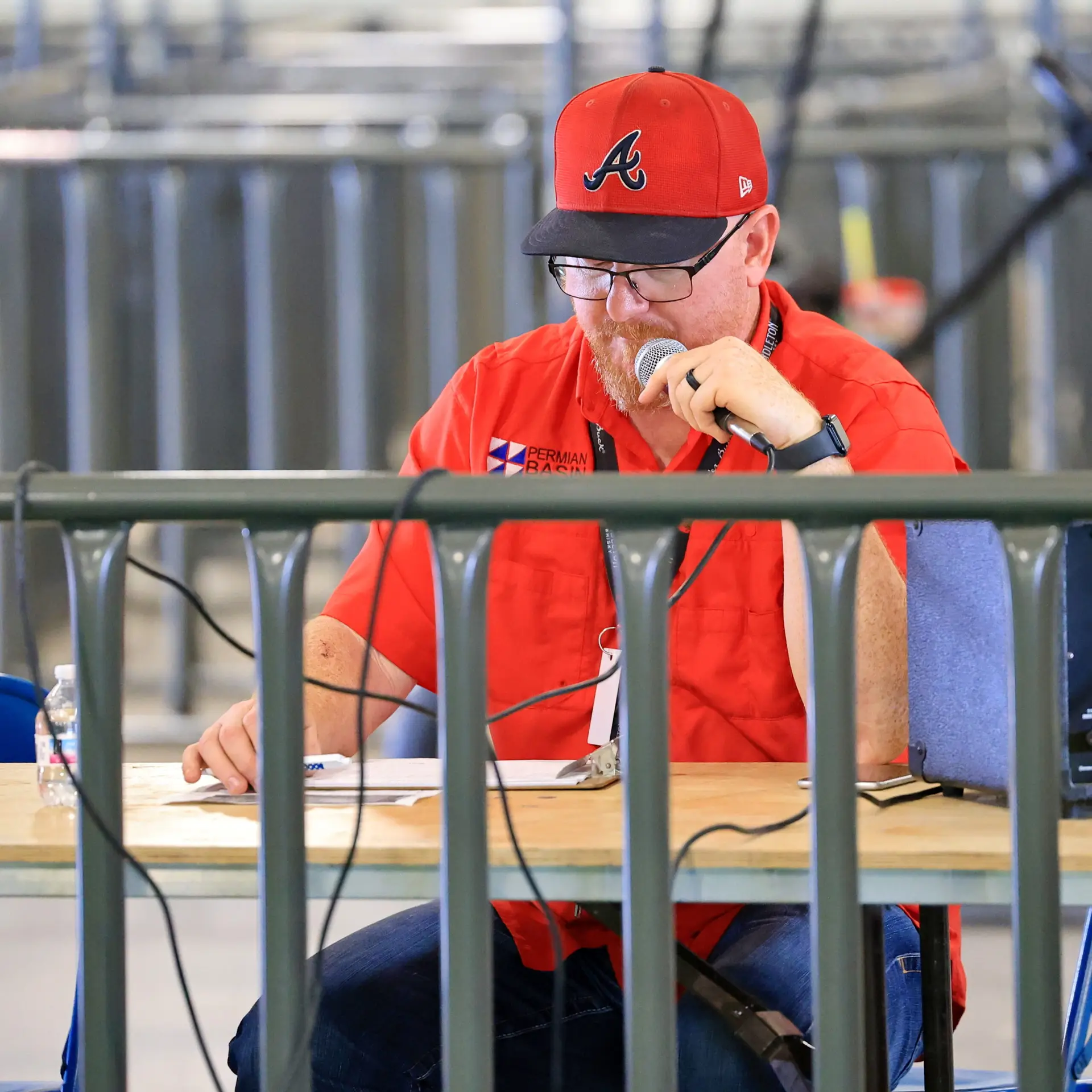Man speaking into microphone at a table.