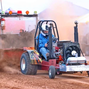 Man driving tractor in a pulling competition.